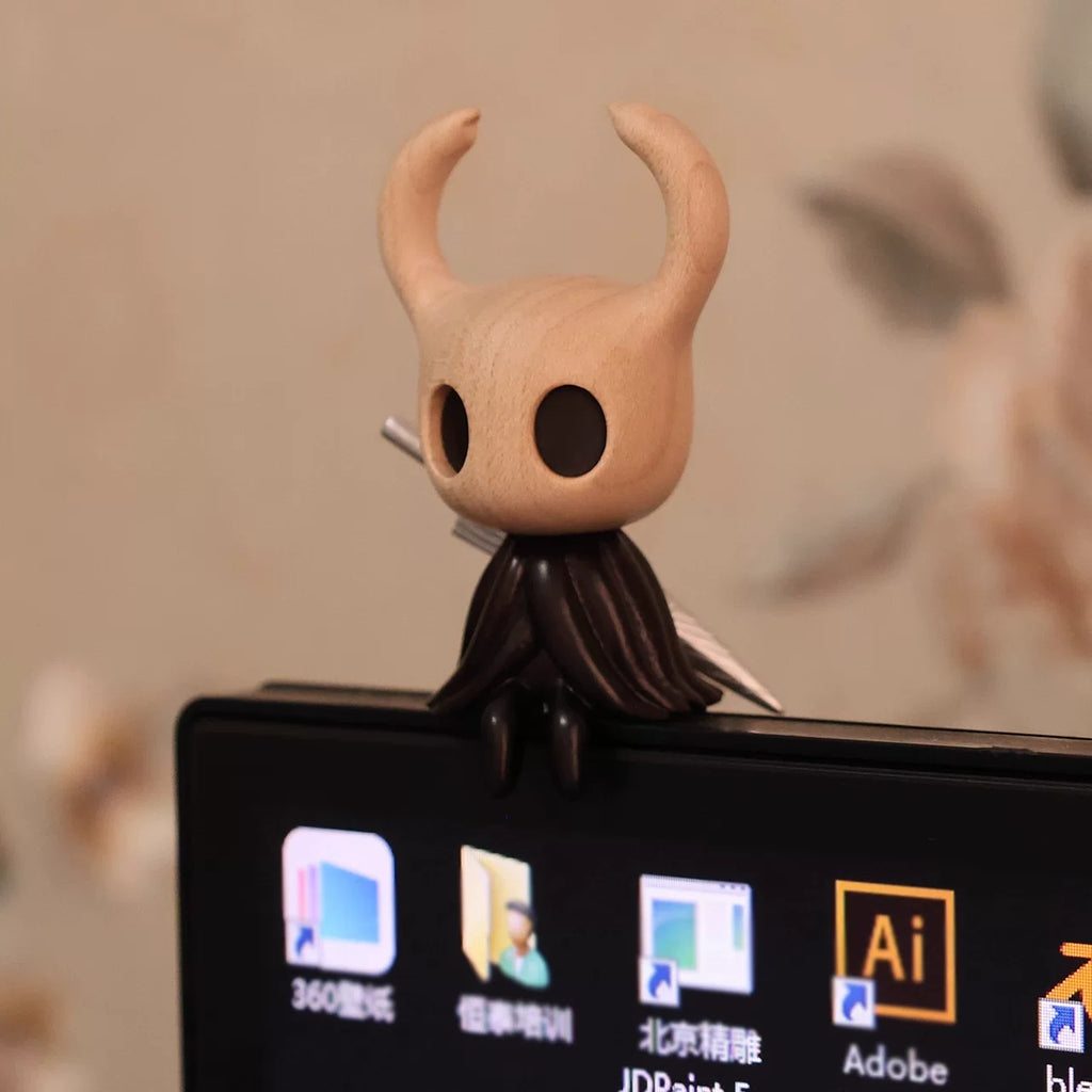 Wooden Hollow Knight sitting on a computer monitor, front view