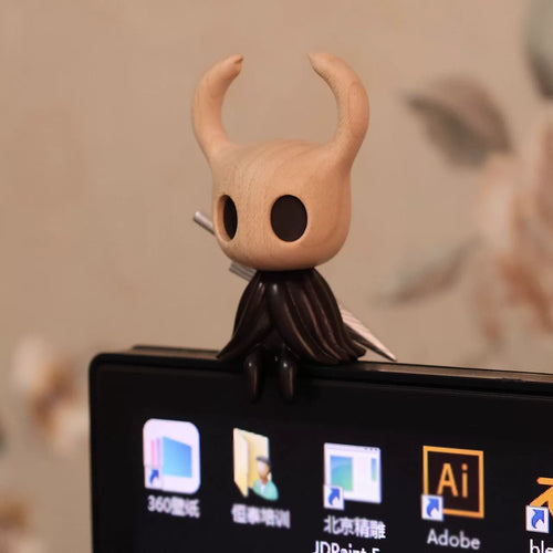 Wooden Hollow Knight sitting on a computer monitor, front view