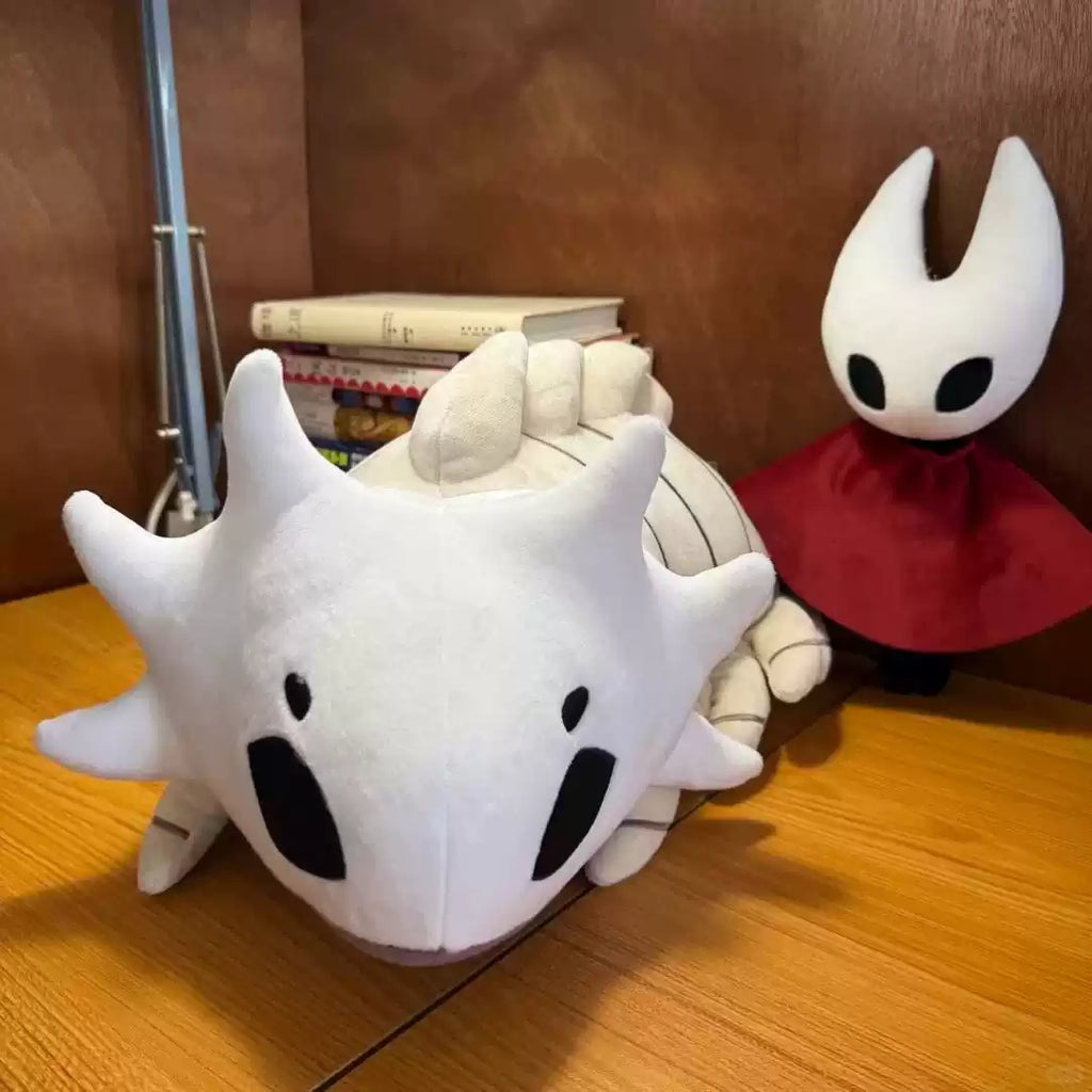 Large white Bell Beast plush displayed on a shelf