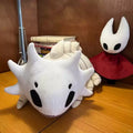 Large white Bell Beast plush displayed on a shelf