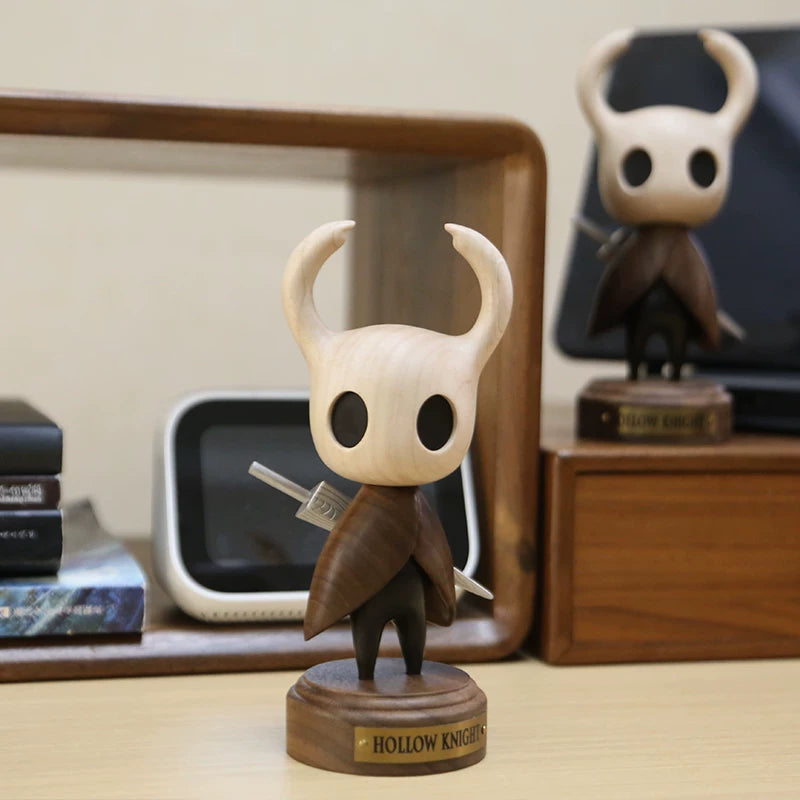 Standing Hollow Knight wooden figure on a display base beside a desk shelf