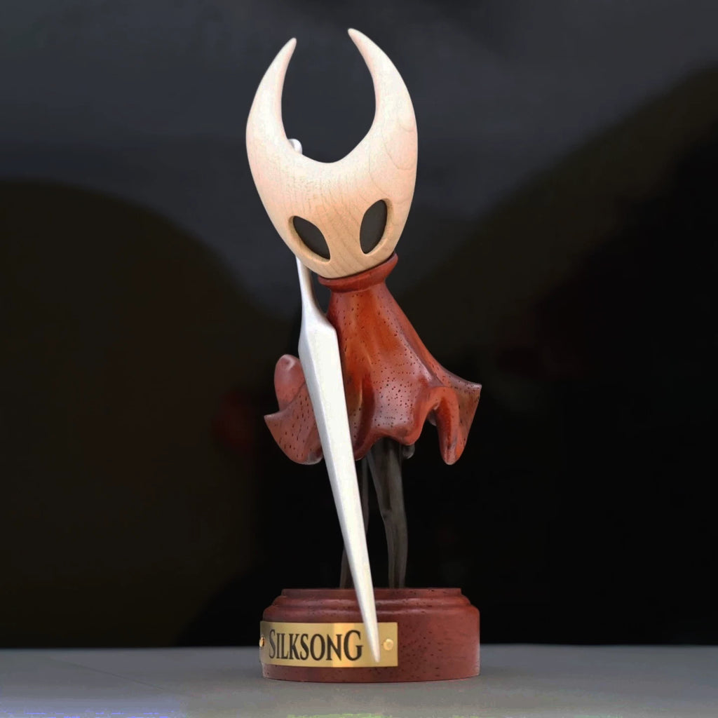 Hornet wooden figure on a Silksong display base against a dark background