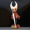 Hornet wooden figure on a Silksong display base against a dark background