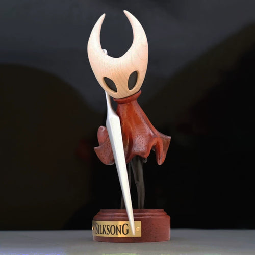 Hornet wooden figure on a Silksong display base against a dark background